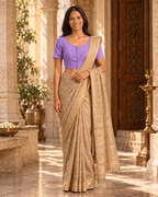 Lavender front-hook saree blouse worn with a gold-bordered beige saree, standing indoors near an ornate doorway