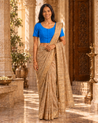 Royal blue front-hook saree blouse worn with a gold-bordered beige saree, standing indoors near ornate pillars